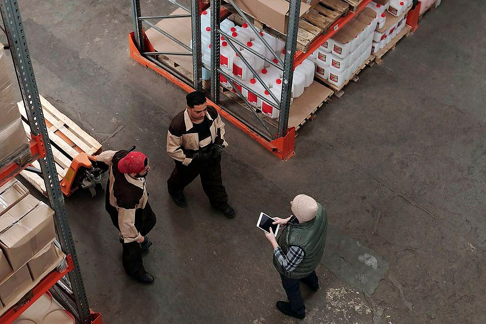 Workers discuss logistics in a busy warehouse setting, enhancing teamwork and efficiency